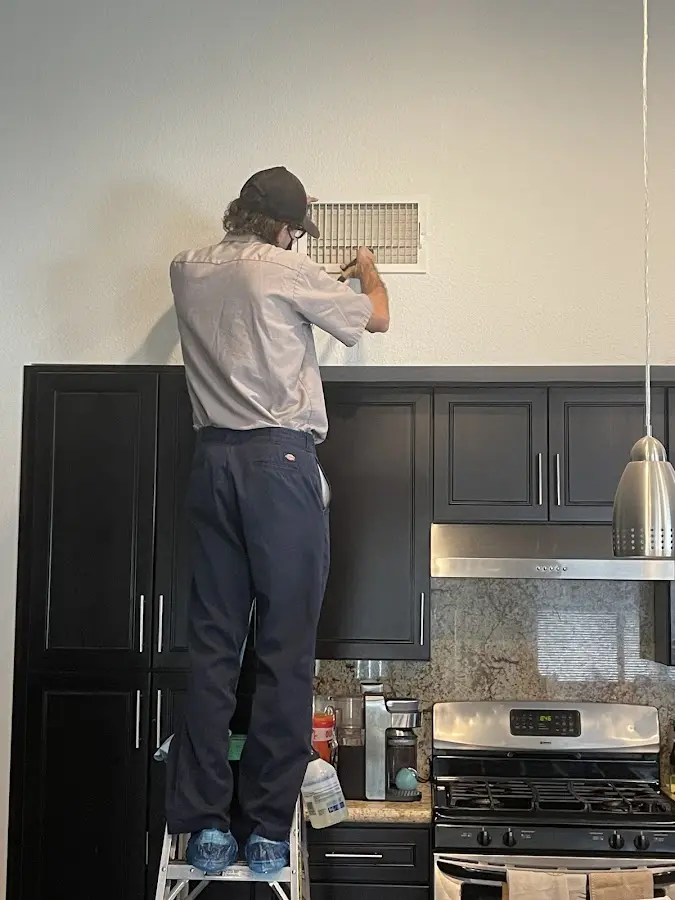 Technician inspecting an air vent during HVAC service in Sunnyvale